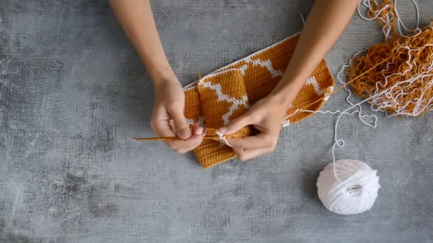 young womans hands crocheting with orange and white cotton thread on stone table background, top view close-up full HD stock video footage in real-time - Footage, Video