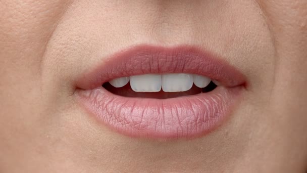 Una donna si lecca le labbra da vicino. Dolce lingua femminile lecca bei denti bianchi. - Filmati, video