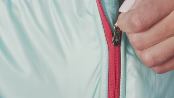 Woman athlete, close up fastens the lock of a sports jacket close up. A lock that fastens a womans clothes. zipper jacket close up closes - Footage, Video
