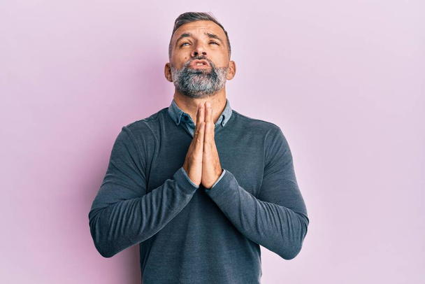 Middle age handsome man wearing casual clothes begging and praying with hands together with hope expression on face very emotional and worried. begging.  - Photo, Image