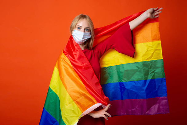 bela jovem mulher com bandeira lgbt em máscara médica - Foto, Imagem