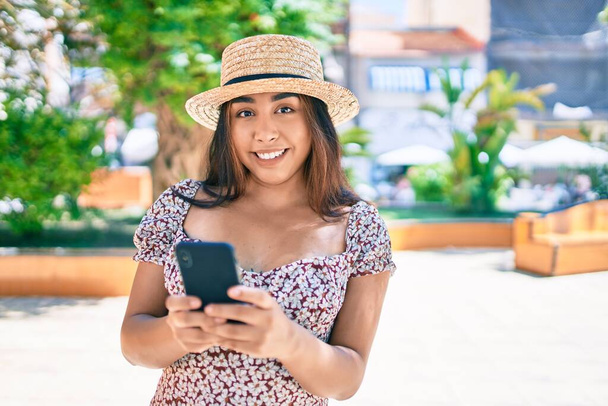 Nuori latino nainen lomalla älypuhelimella kävely kaupungin kadulla. - Valokuva, kuva