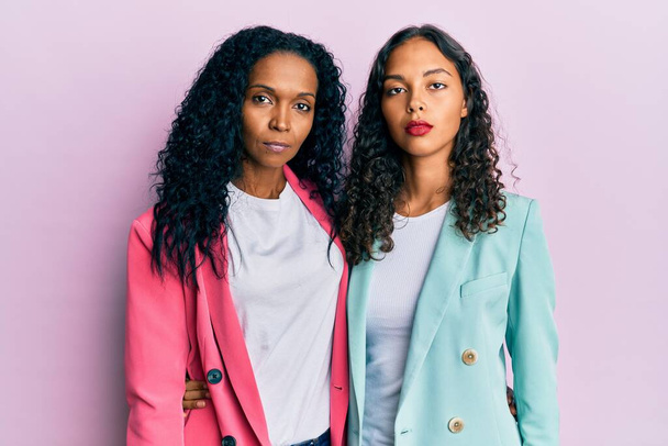 African american mother and daughter wearing business style relaxed with serious expression on face. simple and natural looking at the camera.  - Φωτογραφία, εικόνα