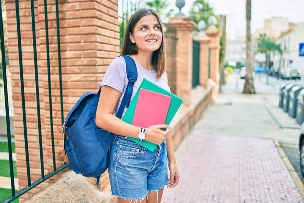 Młoda studentka z Bliskiego Wschodu uśmiechnięta szczęśliwa spacerując po kampusie uniwersyteckim. - Zdjęcie, obraz