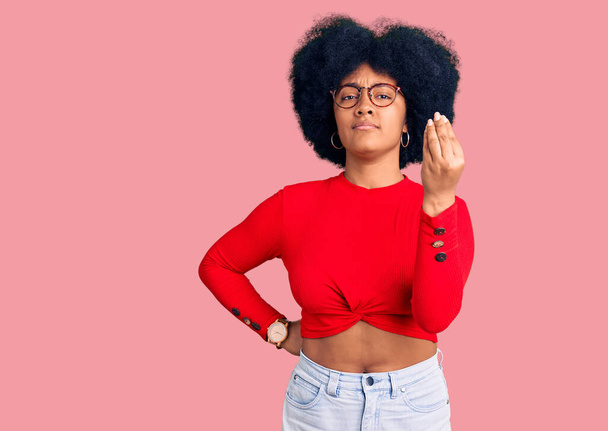 Молода афроамериканка, одягнена в повсякденний одяг і окуляри, роблять італійський жест з рукою і пальцями упевнено вираження.  - Фото, зображення