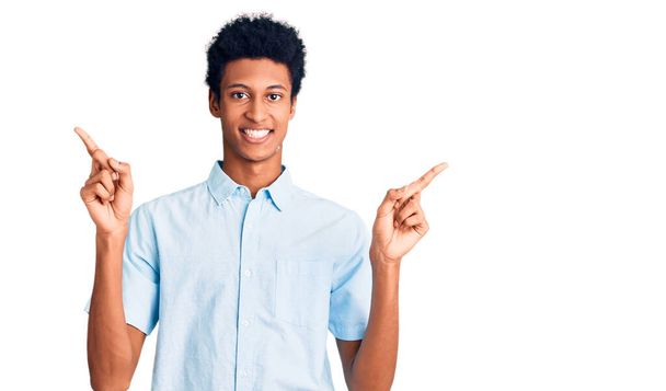 Young african american man wearing casual clothes smiling confident pointing with fingers to different directions. copy space for advertisement  - Fotografie, Obrázek