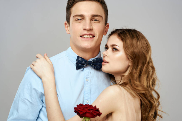 Young couple romance hug relationship dating red rose light studio background - Foto, afbeelding