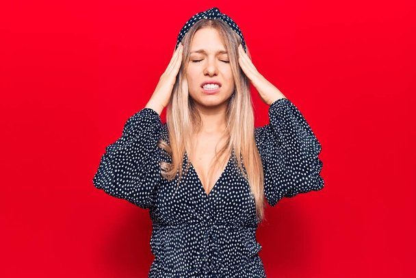 Young blonde woman wearing casual clothes suffering from headache desperate and stressed because pain and migraine. hands on head.  - Foto, Bild