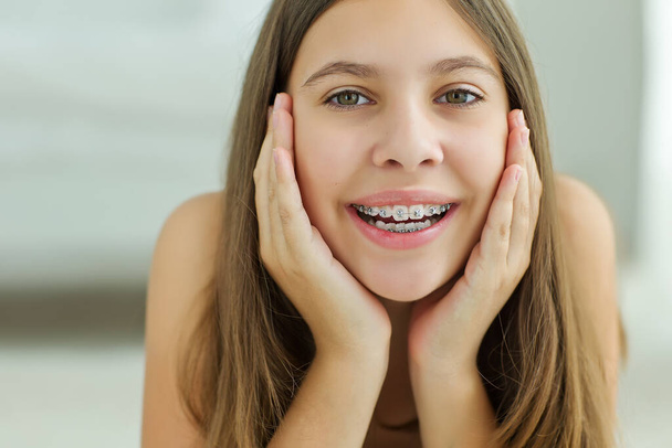 Close up portrait of smiling teenager girl showing dental braces.Isolated on white background. - Photo, image
