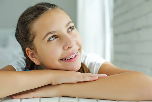 Close up portret uśmiechniętej nastolatki z aparatem dentystycznym.Izolacja na białym tle. - Zdjęcie, obraz