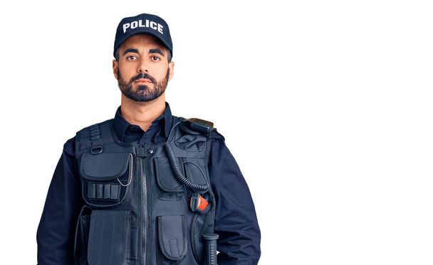 Un joven hispano con uniforme policial relajado con expresión seria en la cara. simple y natural mirando a la cámara.  - Foto, imagen