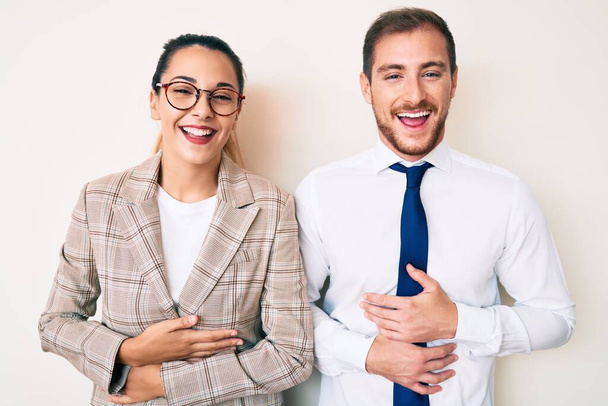 Beautiful couple wearing business clothes smiling and laughing hard out loud because funny crazy joke with hands on body.  - Photo, Image
