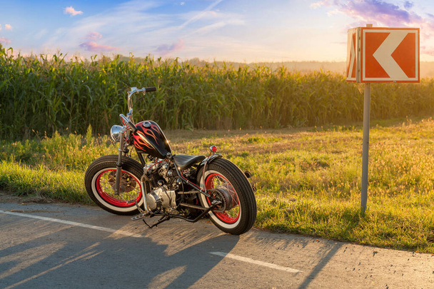 Custom bobber μοτοσικλέτα στέκεται σε ένα δρόμο. - Φωτογραφία, εικόνα