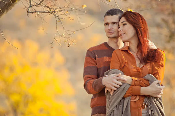 Красивая пара влюблённых мужчин. Улыбающиеся смеющиеся парень и девушка обнимаются в парке осенним осенним днем. - Фото, изображение