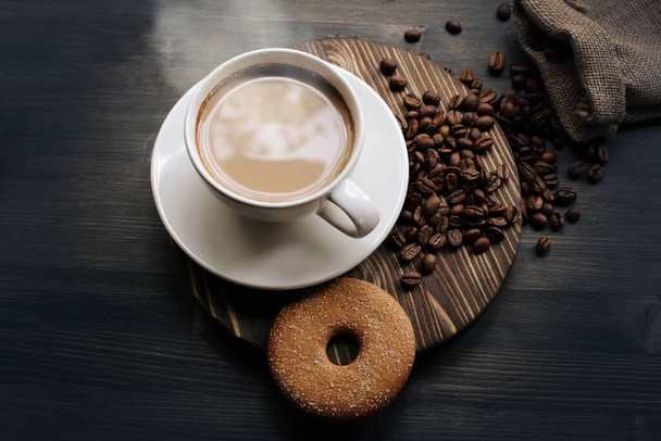 Cup of coffee on a wooden background. Coffee with milk. Coffee beans. - Φωτογραφία, εικόνα