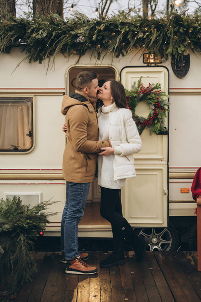 Couple walking on the street near a trailer with new year decor - Foto, afbeelding