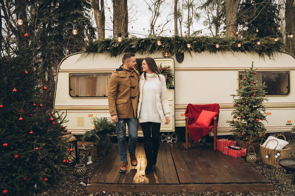 Couple walking on the street near a trailer with new year decor - Photo, image
