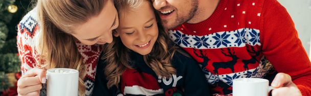 família feliz em suéteres segurando copos com bebidas no Natal, banner - Foto, Imagem