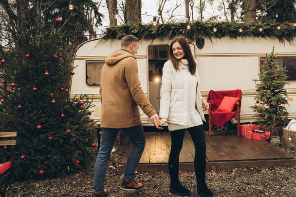 Casal andando na rua perto de um trailer com decoração de ano novo - Foto, Imagem