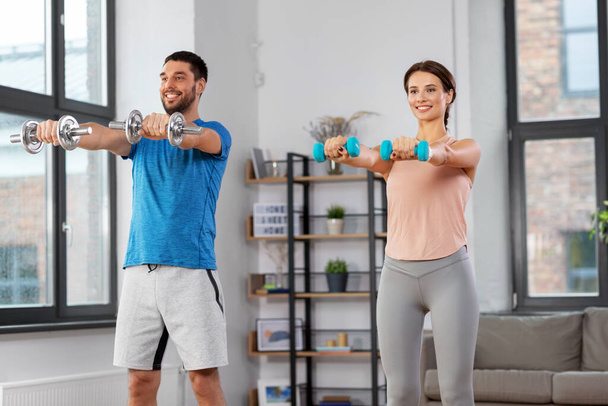 happy couple exercising at home - Фото, изображение