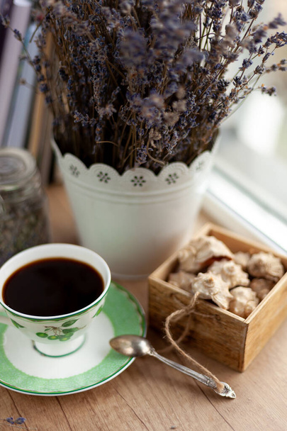 Books, coffee and a bouquet of dried lavender. Still life on the table. Breakfast top view. A cup of invigorating drink. Home cozy background. Ground coffee beans in a jar. Dried flowers. - Foto, Imagen
