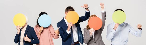 Multiethnic businesspeople covering faces with colorful cards and showing like isolated on grey, banner  - Photo, Image