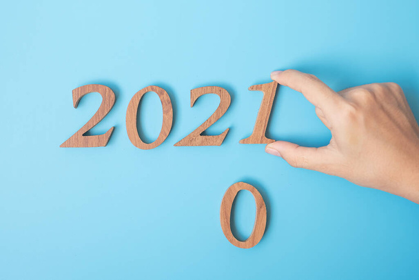 2020 'den 2021' e el değişimi mavi arka planda. Çözüm, strateji, çözüm, hedef, görev, iş, yeni yıl yeni sen ve mutlu tatil kavramları - Fotoğraf, Görsel