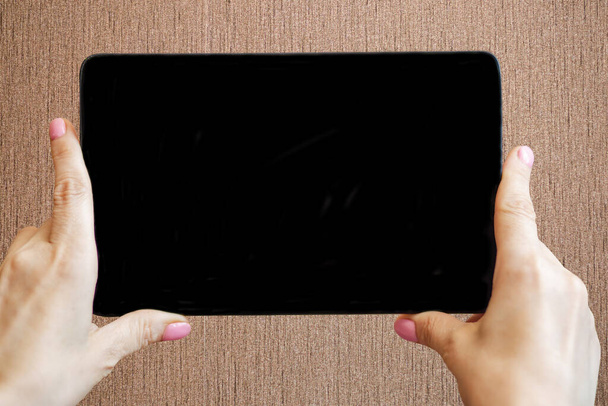 mujer sosteniendo tableta electrónica con pantalla negra vacía - Foto, Imagen