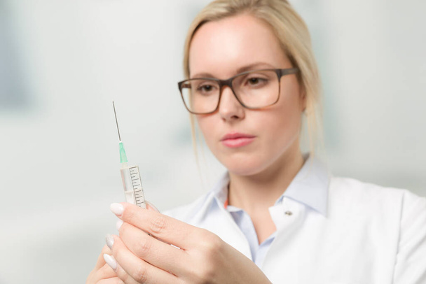 female doctor or nurse with syringe pulled up with a vaccination serum - Photo, Image