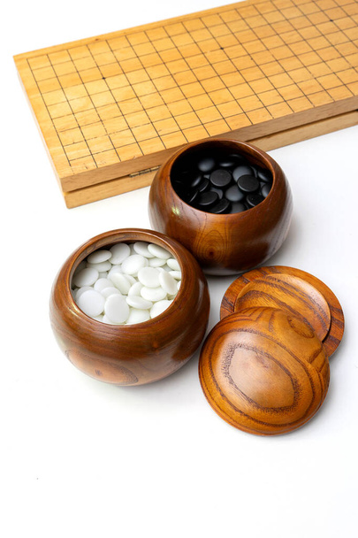 Chinesisches, japanisches, koreanisches Brettspiel GO mit schwarzem und weißem Stein. Go oder wei-Chi - WeiQi traditionelles asiatisches Brettspiel isoliert auf Weiß - Foto, Bild