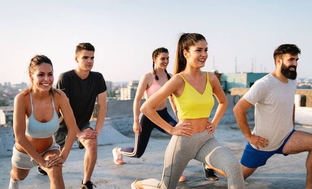 Group of fit happy people training outdoor on the roof - Foto, afbeelding