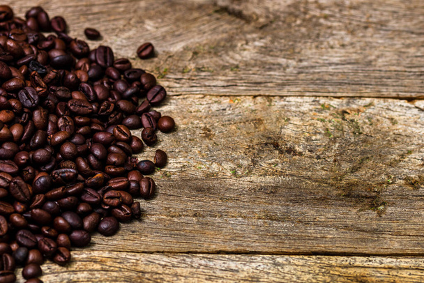 Roasted coffee beans isolated on wooden table. - Photo, Image