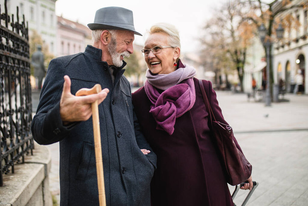 Starší manžel a manželka těší společně při procházce ve městě. - Fotografie, Obrázek