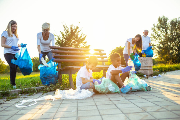Volunteers with garbage bags cleaning up garbage outdoors - ecology concept. - Foto, Imagen