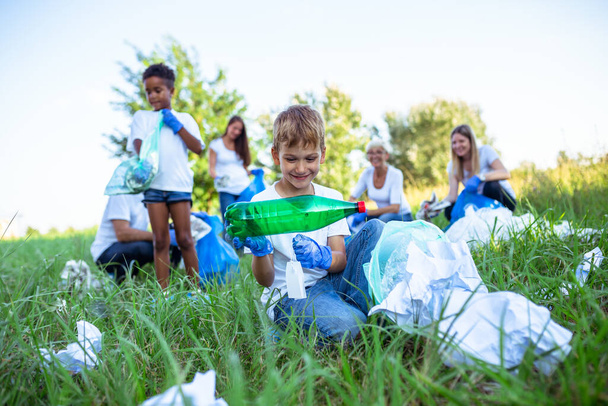 Voluntarios con bolsas de basura limpiando basura al aire libre - concepto de ecología. - Foto, Imagen