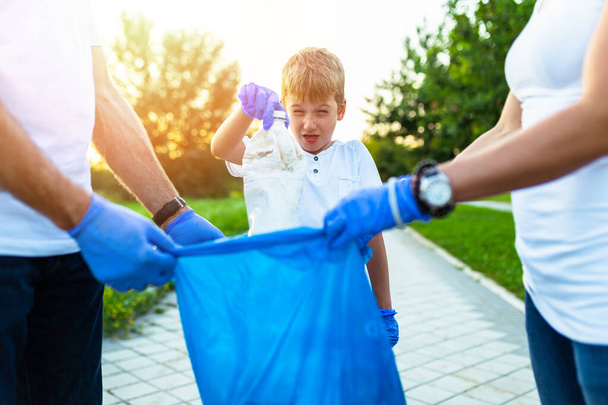 Voluntarios con bolsas de basura limpiando basura al aire libre - concepto de ecología. - Foto, imagen
