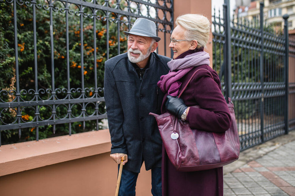 Mature husband and wife enjoying together while walking in the city. - Photo, Image