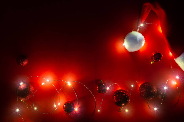 Bannière rouge du Nouvel An avec chapeau de Père Noël, guirlande et boules de paillettes de Noël. Divertissement BDSM. Contexte pour jouets pour adultes ou sex shop. Carte avec une atmosphère de vacances magique. - Photo, image
