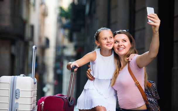 Woman with little daughter traveling together, taking selfie - Photo, Image
