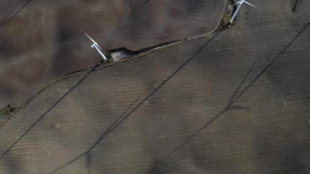 Vliegen boven windturbines in een windmolenpark energieproductie op open grasveld - Video