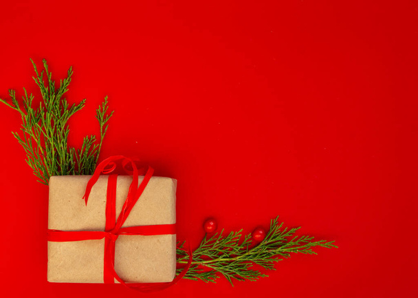 Χριστουγεννιάτικη και Πρωτοχρονιά κάρτα, φόντο - έλατο, δώρα σε κόκκινο φόντο, συμμετρία. Επίπεδη lay, αντίγραφο χώρου, πάνω όψη - Φωτογραφία, εικόνα