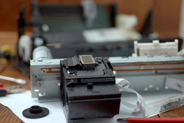 Printer disassembled into parts. Repair of the printer. Print head of the printer close-up. - Foto, imagen