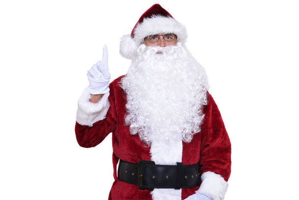 Senior man in traditional Santa Claus costume with one finger pointing up. Number one concept.  - Foto, imagen