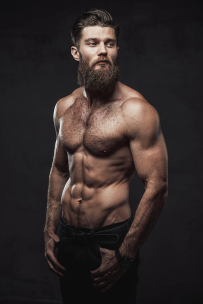Naked and muscular guy posing in dark background - Photo, Image