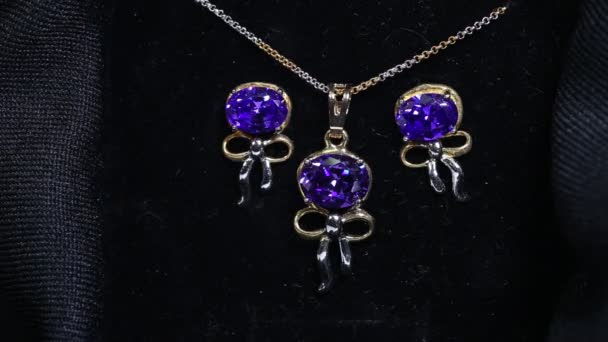 Набор ювелирных изделий, который включает в себя ожерелье, представил золотую цепочку с аметистовым фиолетовым на золотой кулон и набор серёжек - Кадры, видео