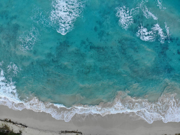An aerial shot of the beautiful wavy ocean hitting the sandy beach - great for wallpapers - Fotó, kép