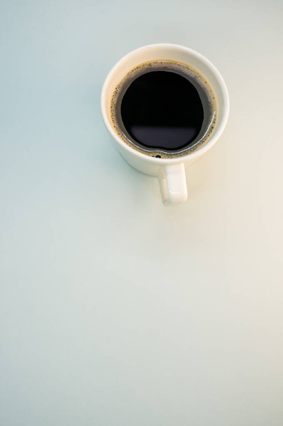 A vertical shot of a cup of coffee on a white surface - Photo, image