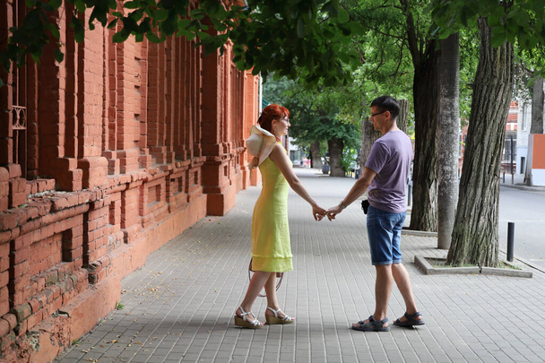 Young couple hold hands and smile while looking at each other. Strong happy relationship concept - Photo, Image