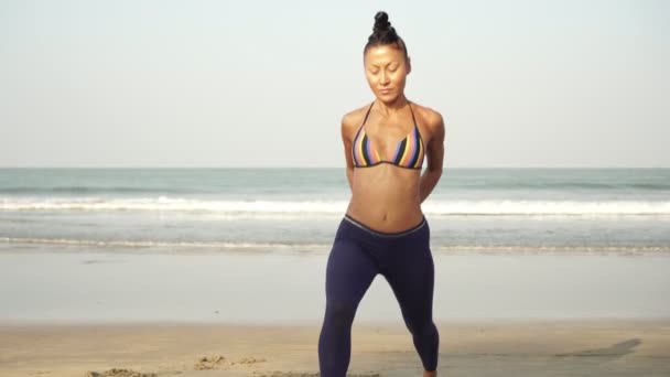 volwassen vrouw gaat in voor sport en warm-up op de zee strand - Video