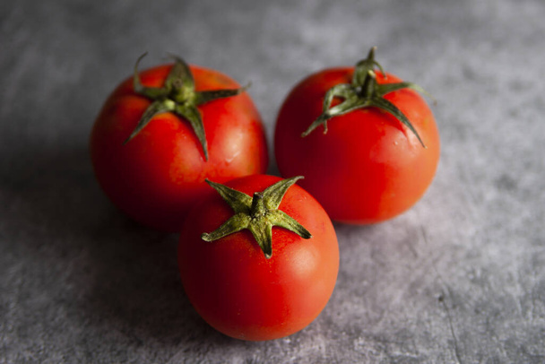 A closeup of ripe, red tomatoes on wooden surface - Photo, image